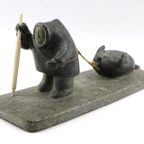 Hunter Pulling Seal - sculpture by Inuit artist Sammy Nassak